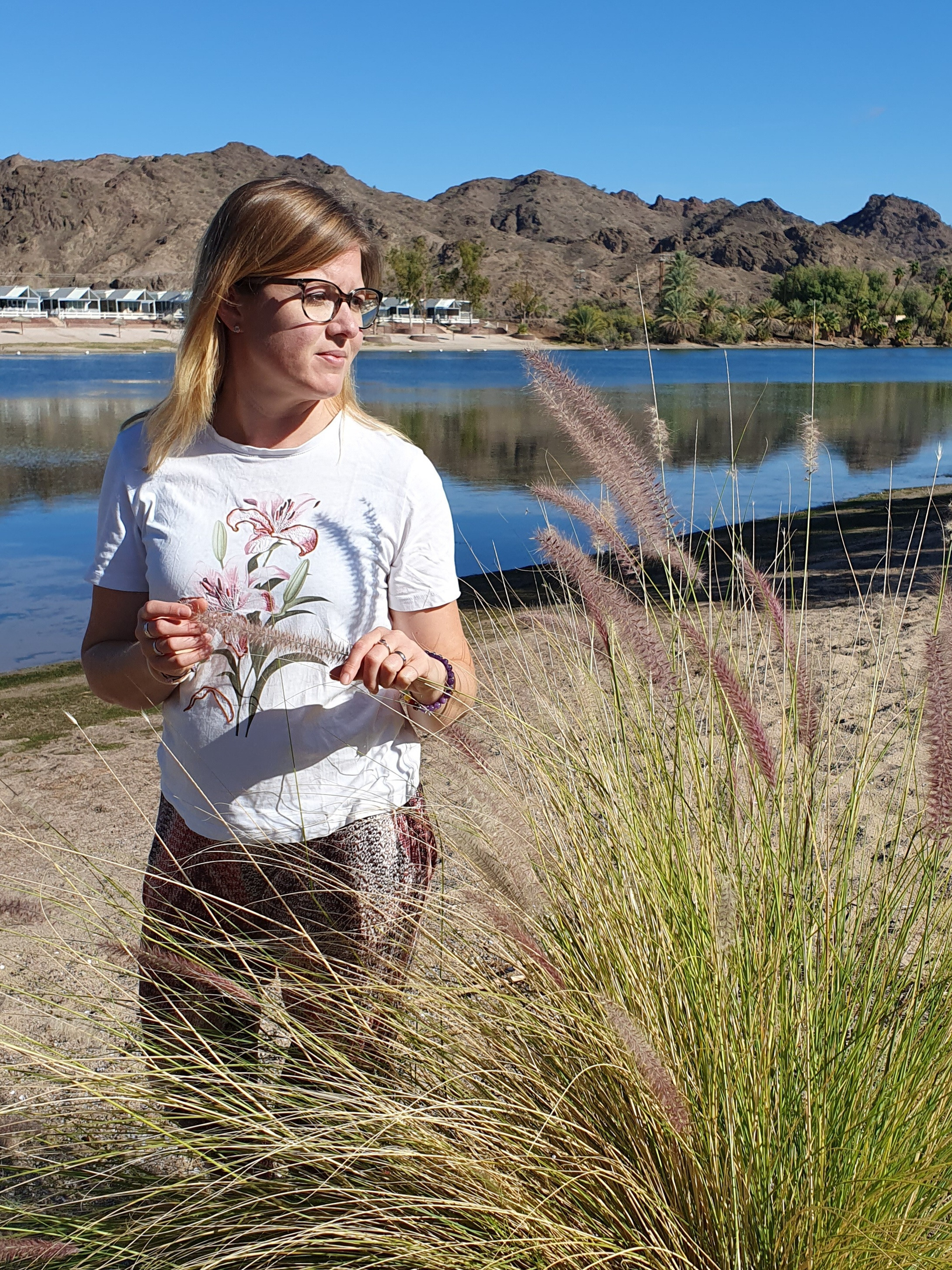 Barbara Hächler sitzt in mitten eines Blumengartens und lächelt freundlich und zugewandt im Bild.